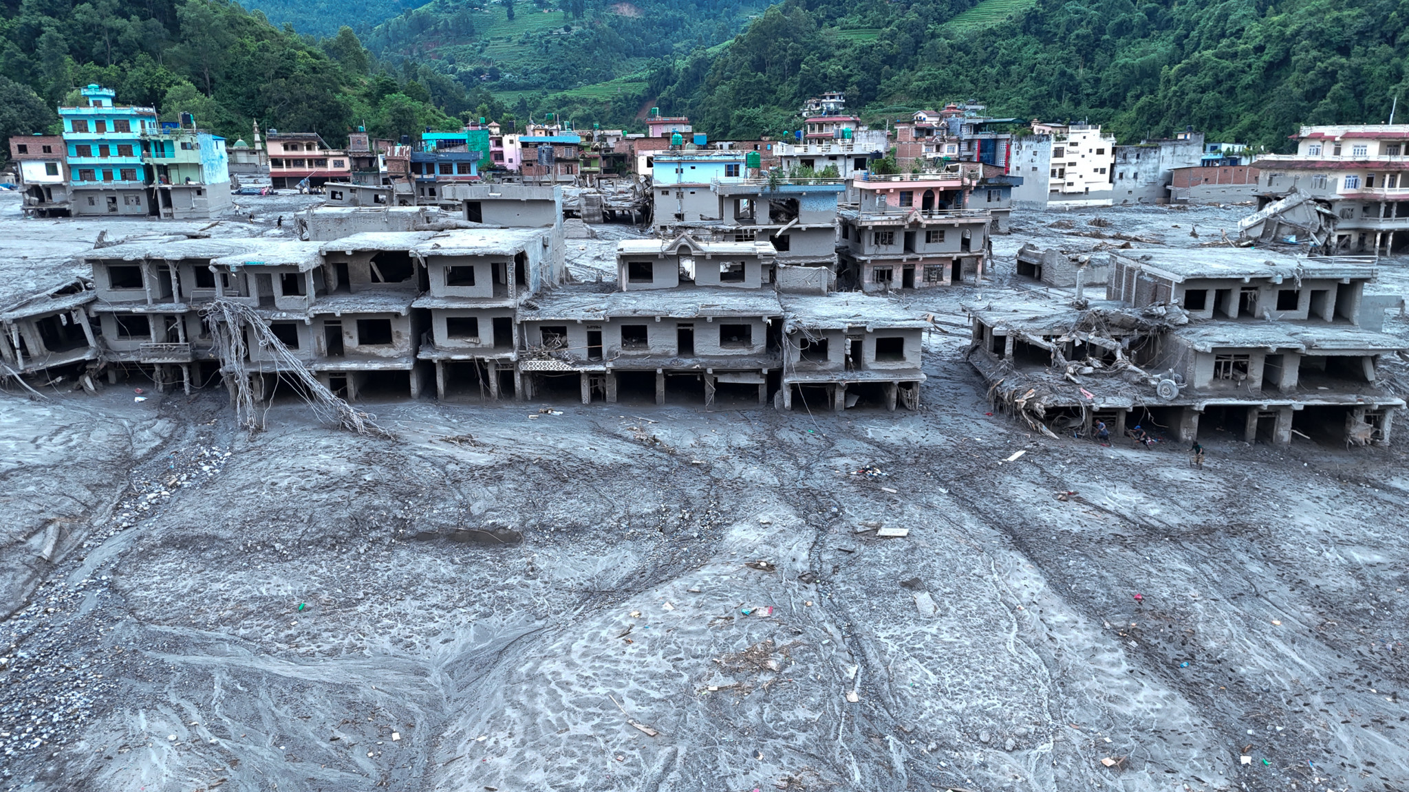 Luftaufnahme von DevGhat, Nepal: Schlamm und Geröll bedecken Gebäude nach verheerenden Überschwemmungen im August 2026.