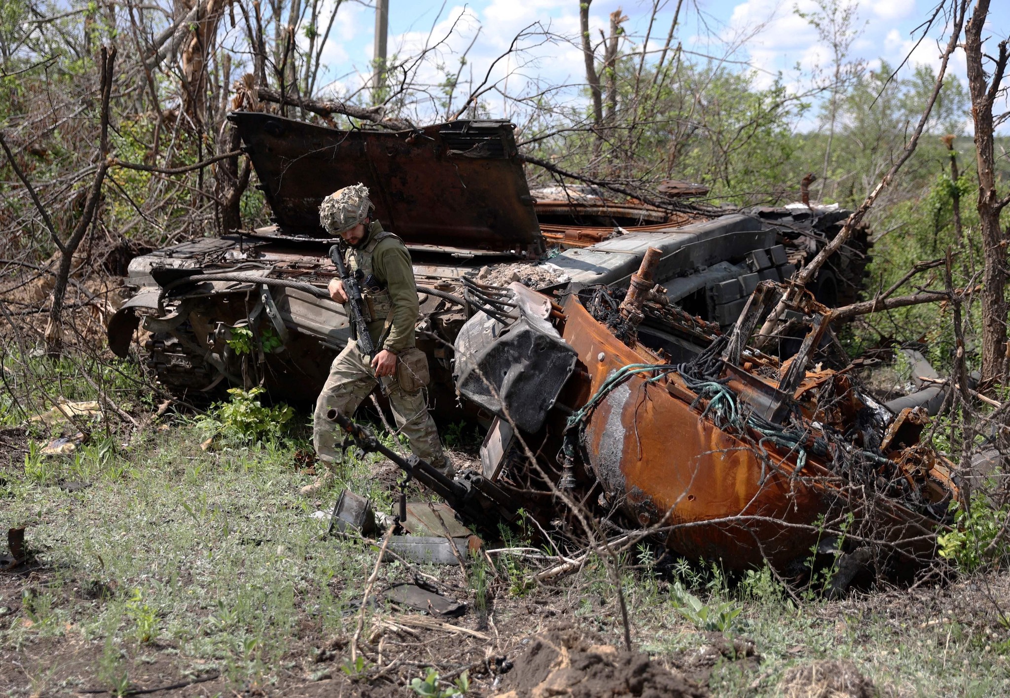 A Ukrainian servicemen inspects a destroyed Russian tanks at an abandonned Russian position near the village of Bilogorivka not far from Lysychansk, Lugansk region, on June 17, 2022, amid the Russian invasion of Ukraine. (Photo by Anatolii STEPANOV / AFP)