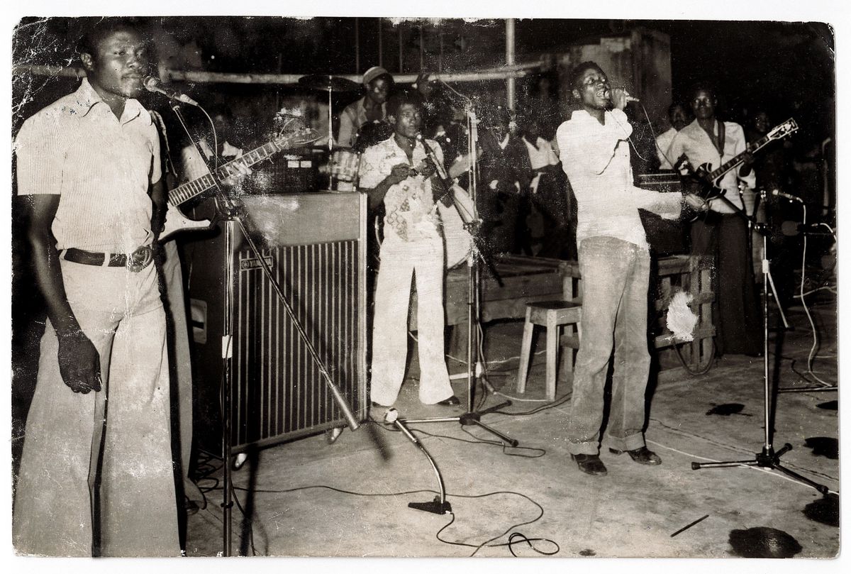 Groupe de musiciens énergiques jouant de la musique avec des instruments sur scène.