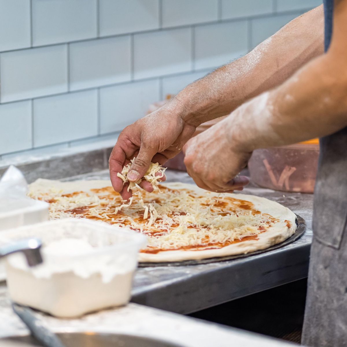 Cuisinier préparant une pizza artisanale dans un camion de street food.