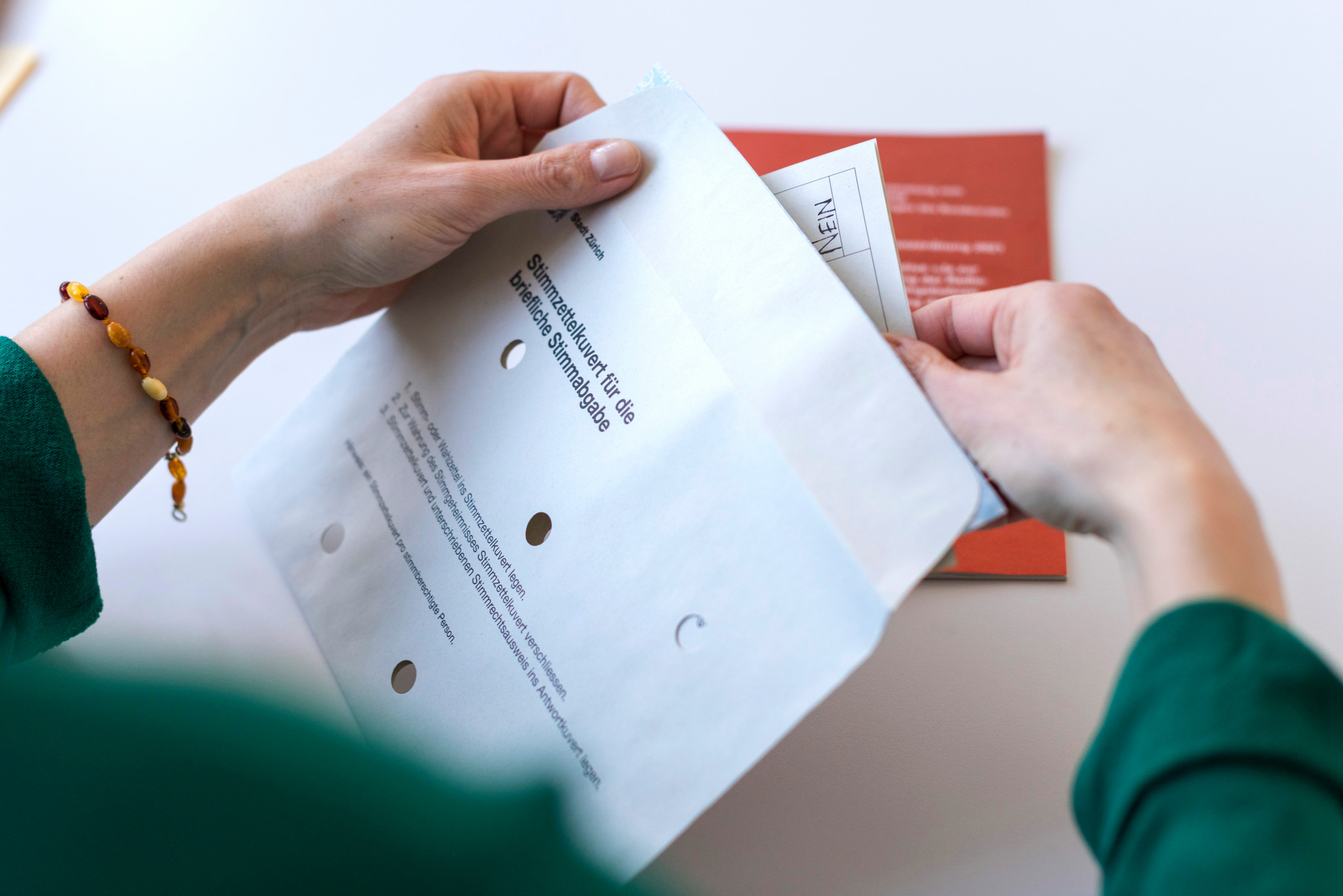 Hände halten Abstimmungsunterlagen für die Volksabstimmung vom 4. März 2018 in Zürich.