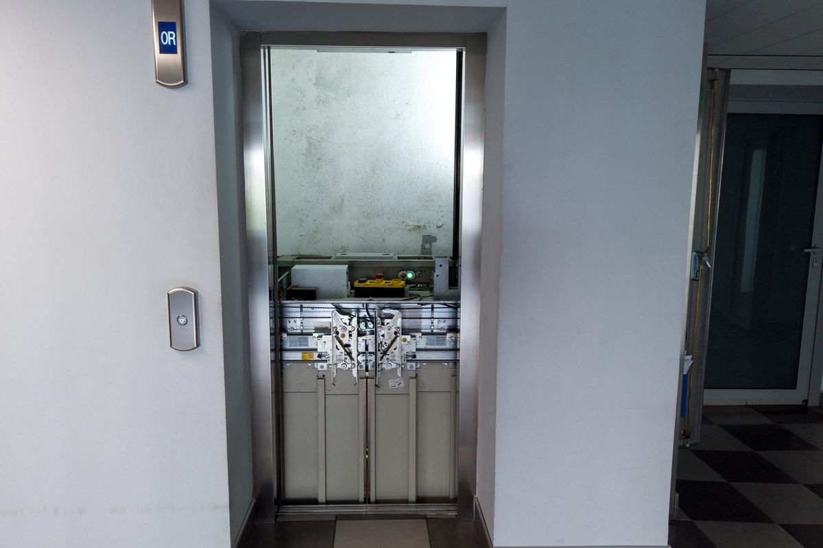 Ascenseur en panne avec porte ouverte et panneau signalant ’hors service’.
