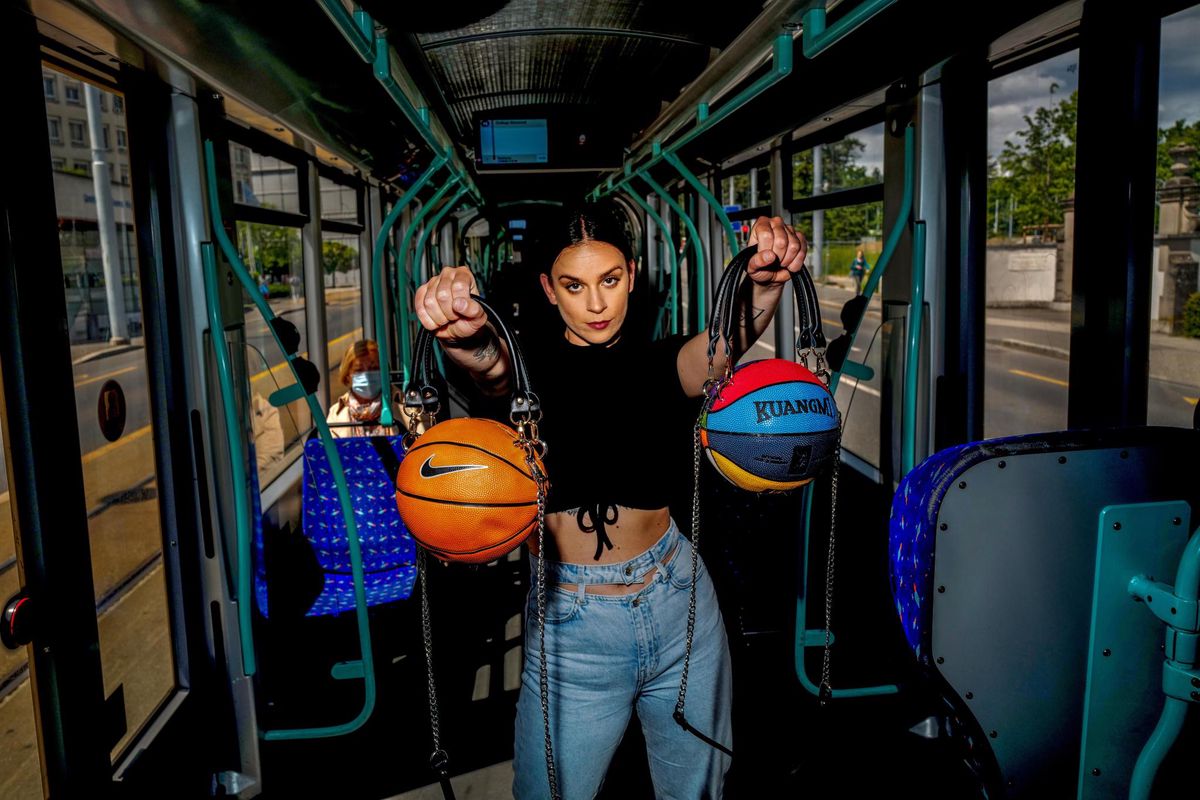 Joana Bender de la Fripe à Jo pose dans le tram avec ses créations: des ballons de basket transformés en sac à main.
