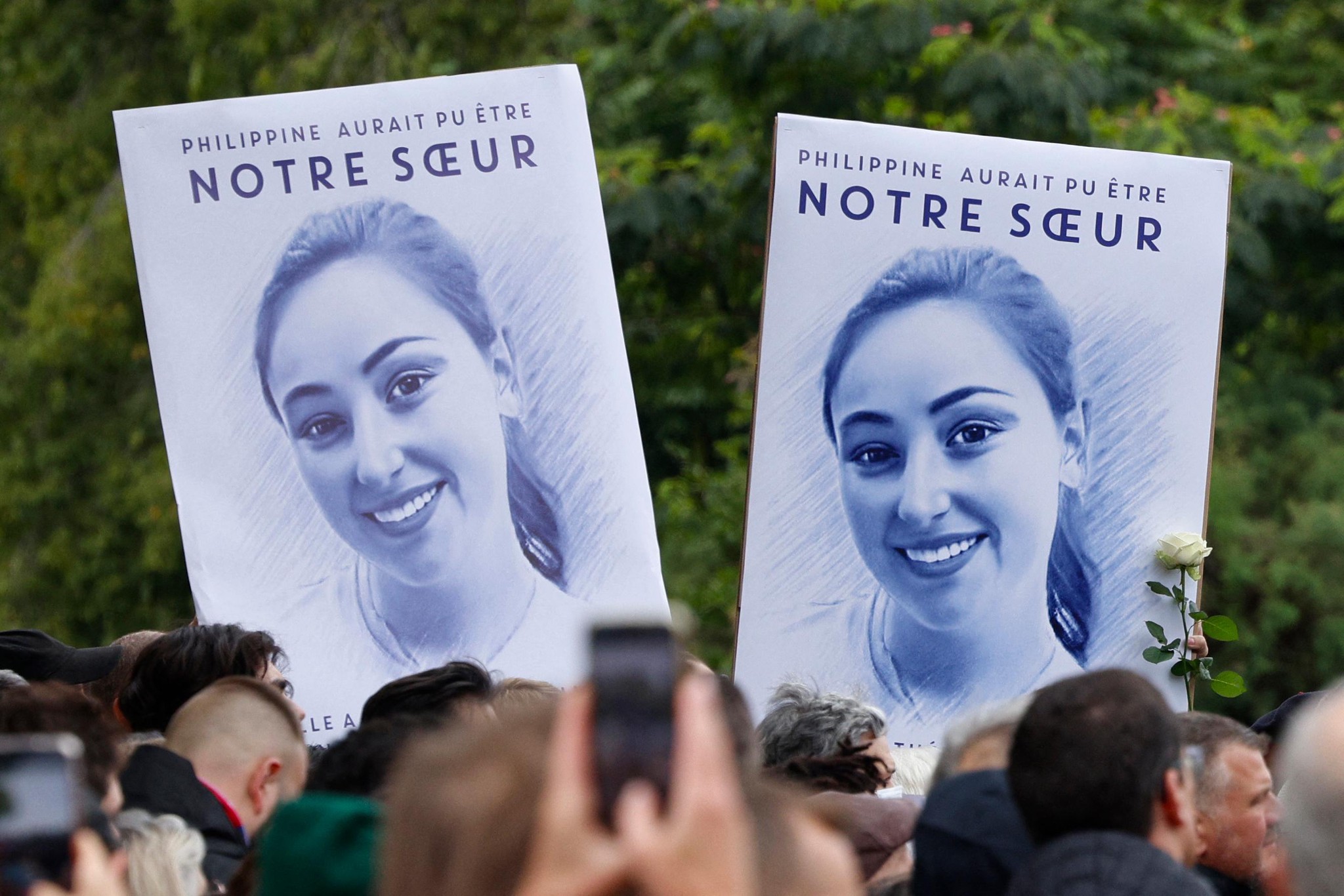 Participants brandissant des affiches avec le portrait de Philippine lors d'une réunion hommage à Paris, hommage organisé par Nemesis.