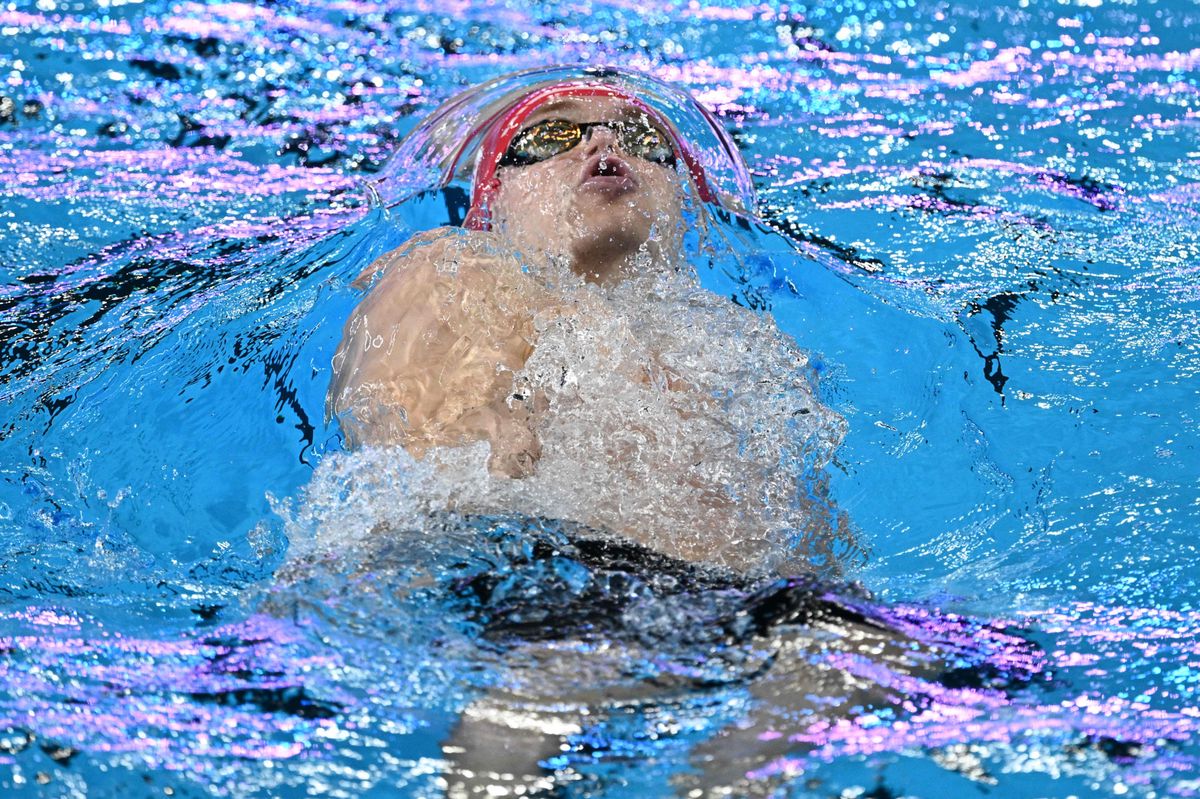 Switzerland's Roman Mityukov competes in a heat of the men's 200m backstroke swimming event during the 2024 World Aquatics Championships at Aspire Dome in Doha on February 15, 2024. (Photo by SEBASTIEN BOZON / AFP)