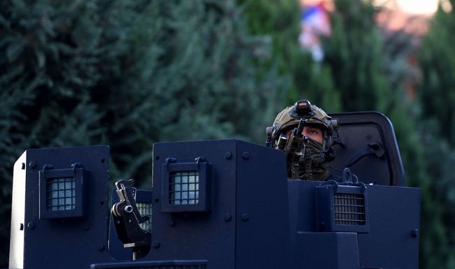 A police officer looks on as Kosovo police officers search a restaurant and building in northern Serb-dominated part of ethnically divided town of Mitrovica on September 29, 2023. Kosovo on September 29, 2023 called for international sanctions against Serbia, claiming that Belgrade had supplied the weapons used by gunmen suspected of having killed a Kosovo police officer at the weekend. The killing and an ensuing gun battle at a monastery in a village close to the Serbian border marked one of the gravest escalations in the former breakaway province in years. (Photo by STRINGER / AFP)