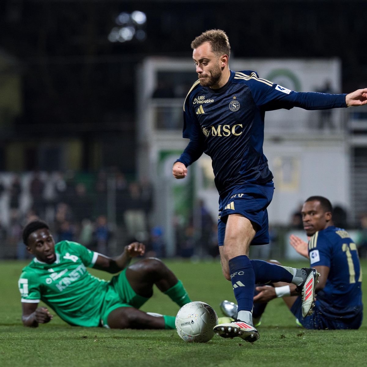 Timothe Cognat du Servette FC en action avec Moussa Baradji d’Yverdon et Dereck Kutesa (SFC) au sol lors du match Yverdon Sport FC contre Servette FC en Super League au Stade Municipal d’Yverdon.
