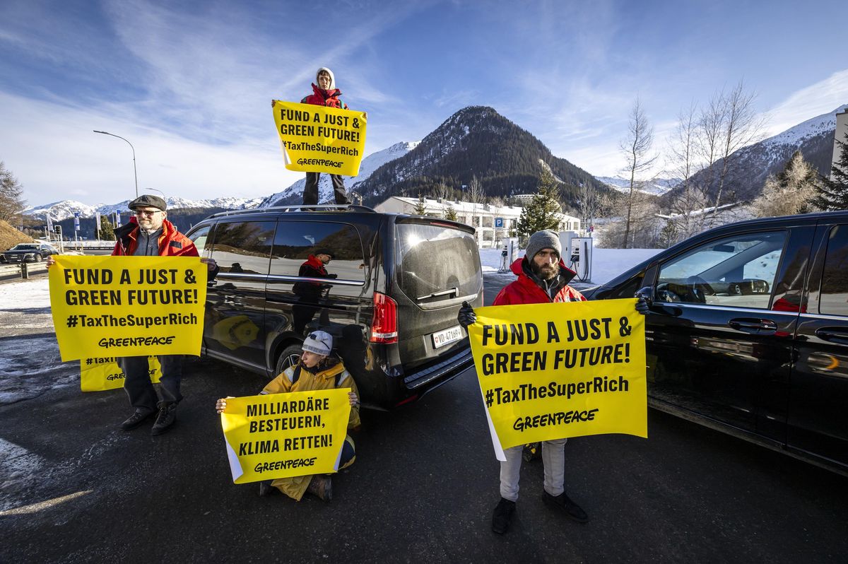 Des militants de Greenpeace bloquent une route à Davos Dorf, tenant des pancartes contre les riches pour défendre l’avenir écologique durant le Forum Économique Mondial.