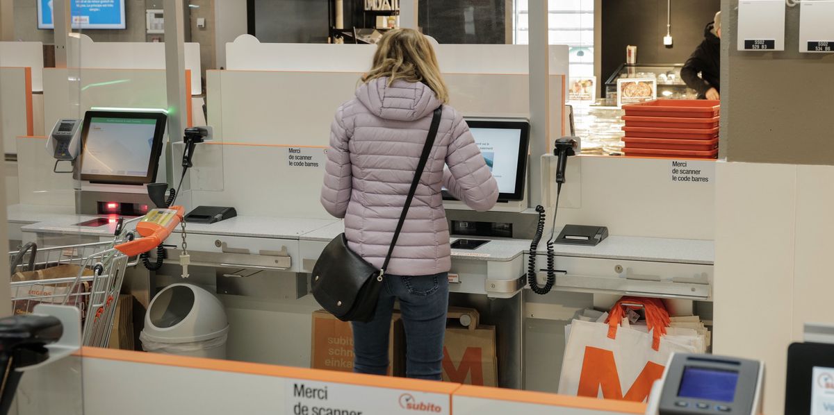 Carouge, le 24 mars 2023. Une femme utilise la caisse automatique de la Migros Vibert.