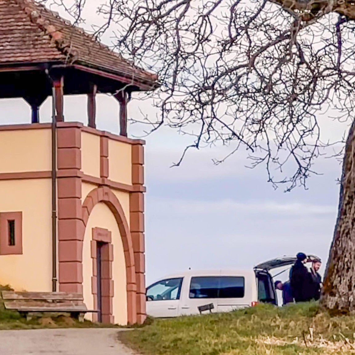 Region bei Steinen-Hüsingen im Landkreis Lörrach: Kleines Gebäude neben einem Baum auf einer Wiese, im Hintergrund Polizeiaktivität.