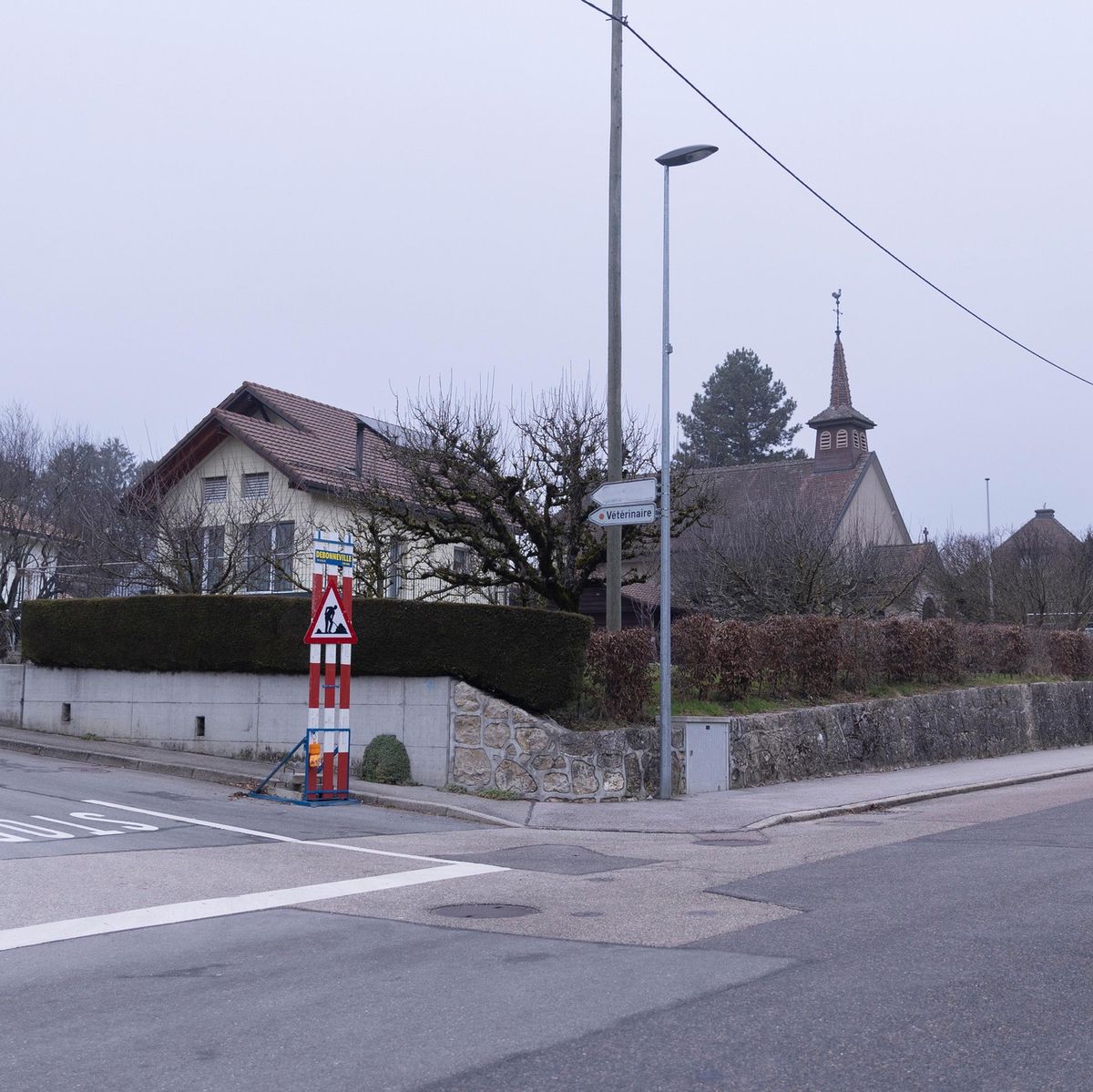 Scène du crime à Bière, montrant une rue calme avec des maisons et une église en arrière-plan.