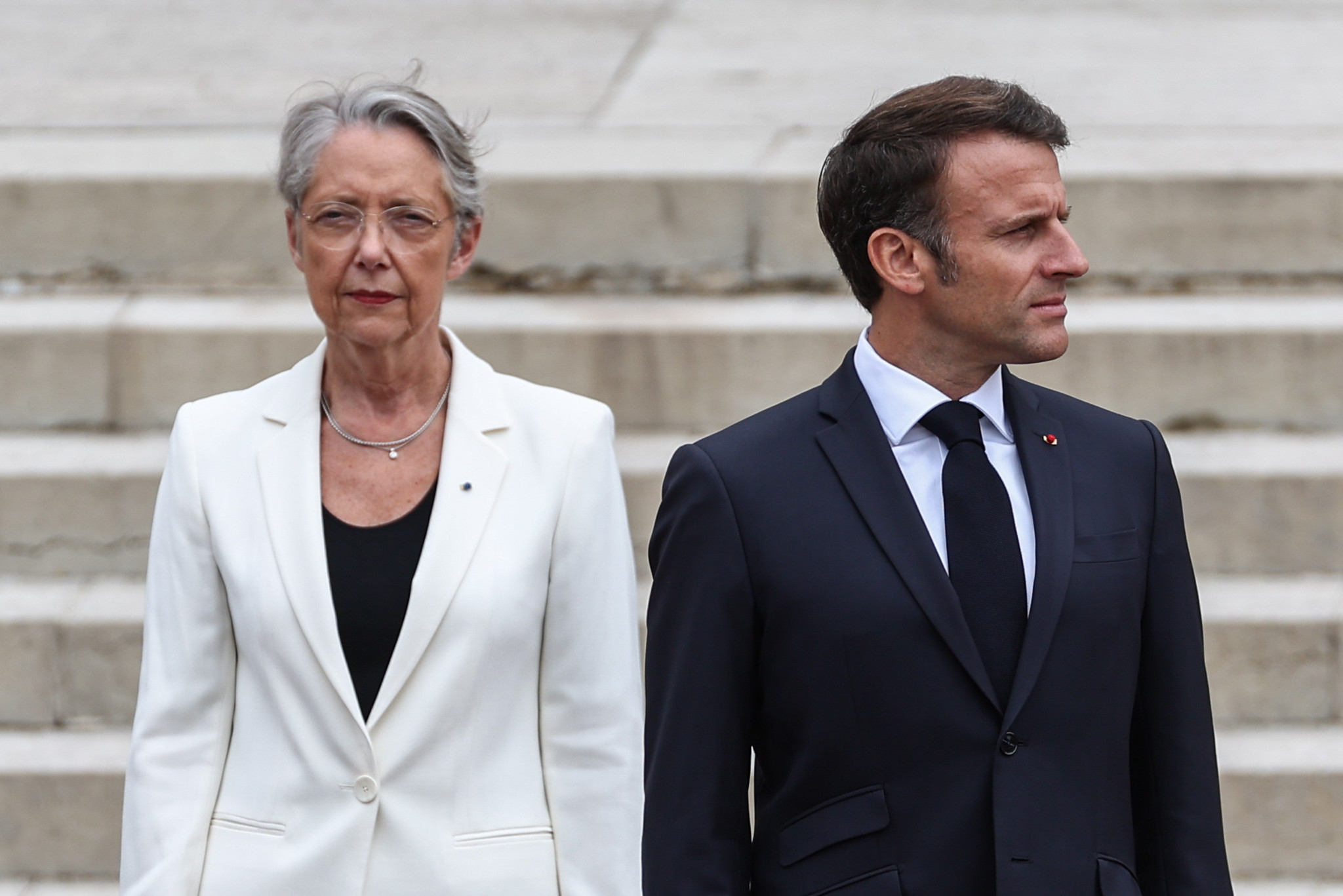 epa10698521 French President Emmanuel Macron (R) and French Prime Minister Elisabeth Borne attend a WWII ceremony marking the 83rd anniversary of late French General Charles de Gaulle's resistance call of 18 June 1940, at the Mont Valerien memorial in Suresnes near Paris, France, 18 June 2023.  EPA/MOHAMMED BADRA / POOL