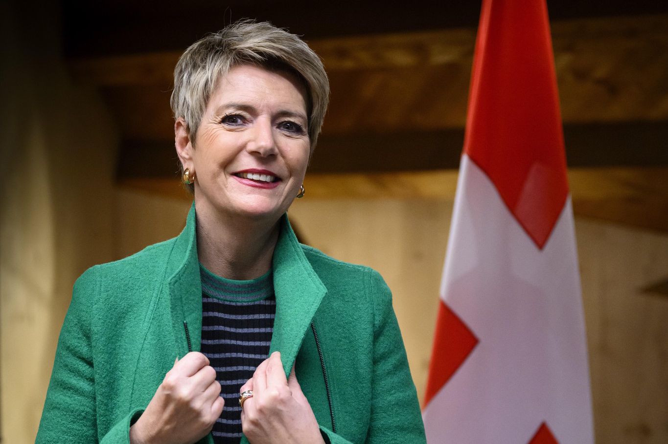 La Conseillère fédérale suisse Karin Keller-Sutter posant devant un drapeau suisse lors du Forum économique mondial à Davos, 2024.