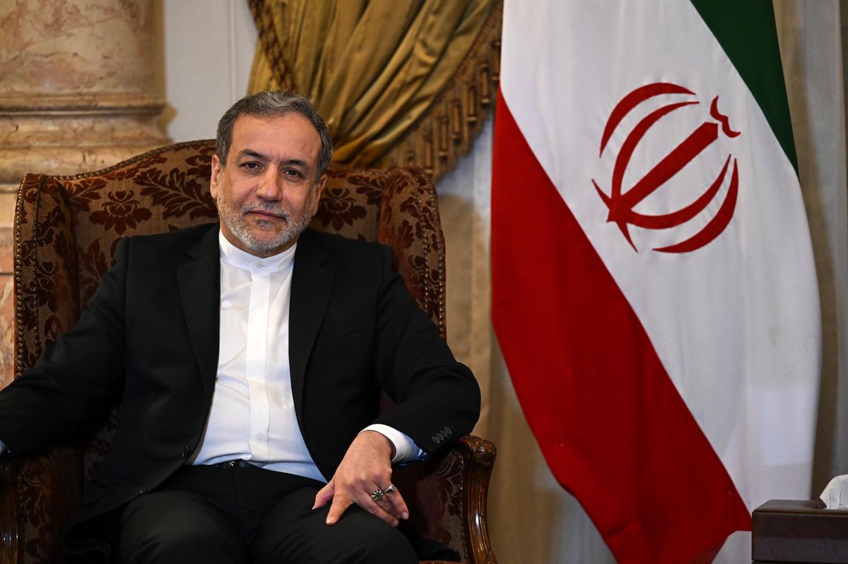 Le ministre iranien des Affaires étrangères, Abbas Araghchi, assis devant un drapeau iranien lors de sa visite au Caire, Égypte, le 17 octobre 2024.
