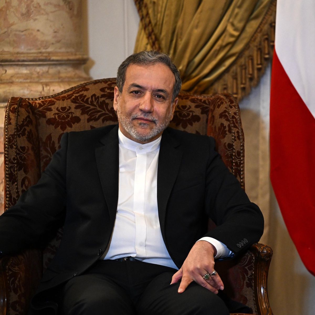 Le ministre iranien des Affaires étrangères, Abbas Araghchi, assis devant un drapeau iranien lors de sa visite au Caire, Égypte, le 17 octobre 2024.