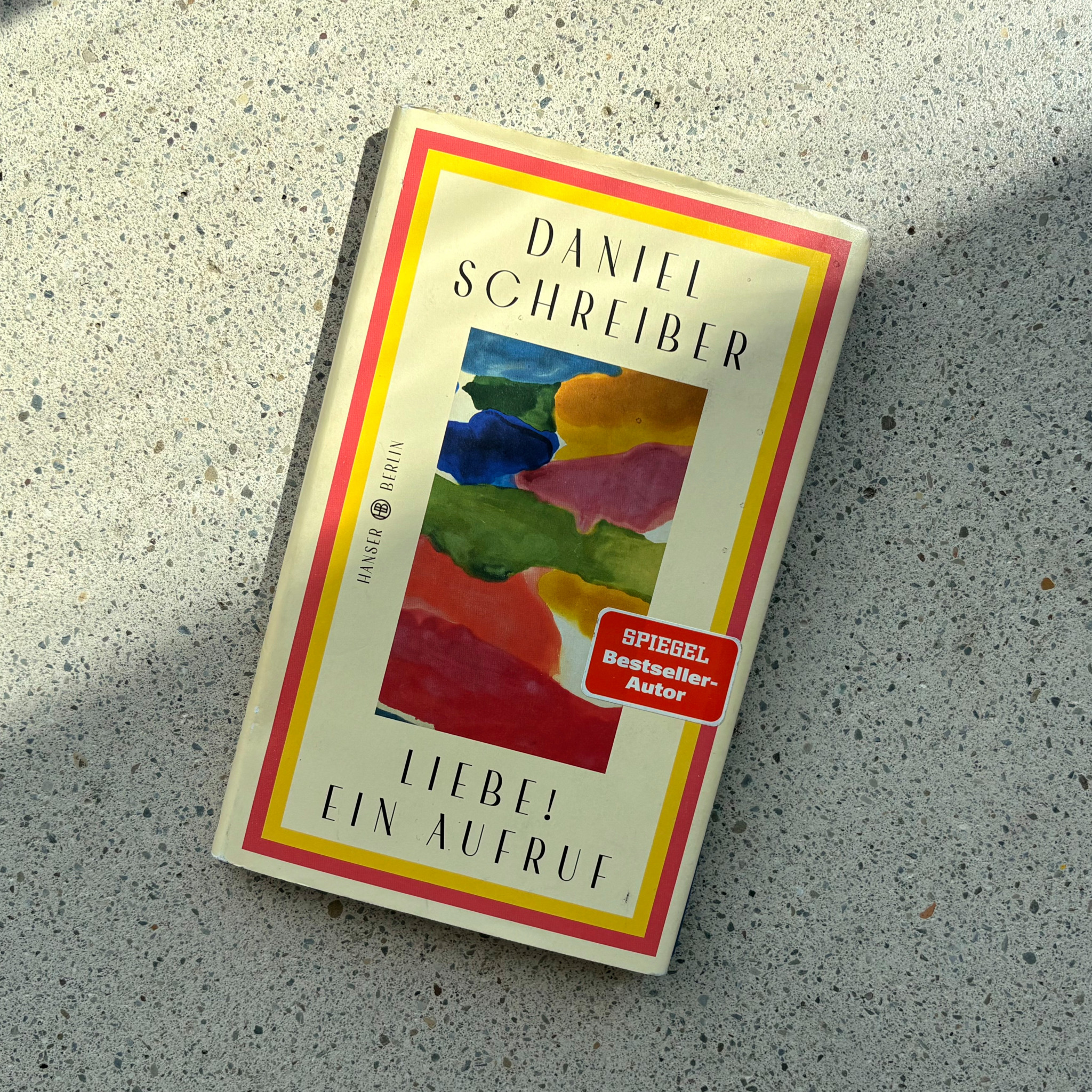 Buchcover ’Liebe! Ein Aufruf’ von Daniel Schreiber mit bunten Aquarellflecken, ausgezeichnet als Spiegel-Bestseller-Autor.