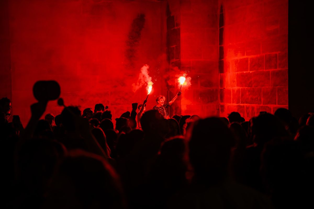 Des femmes manifestent sur l'esplanade de la cathedrale lors du lancement en soiree de la Greve feministe le mardi 13 juin 2023 a Lausanne. (KEYSTONE/Jean-Christophe Bott)