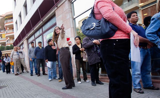 Des chômeurs espagnols font la queue à un office pour l'emploi.