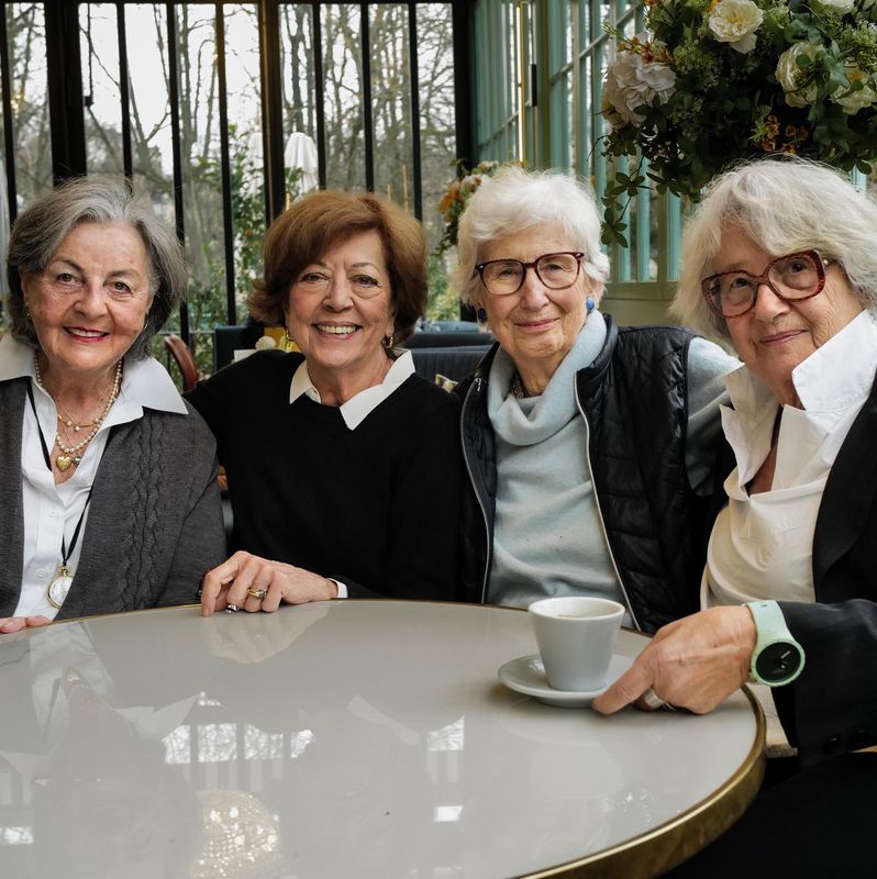 Quatre octogénaires genevoises assises autour d’une table dans un café, de gauche à droite: Françoise, Jacqueline, Murielle et Arlette, discutant joyeusement.
