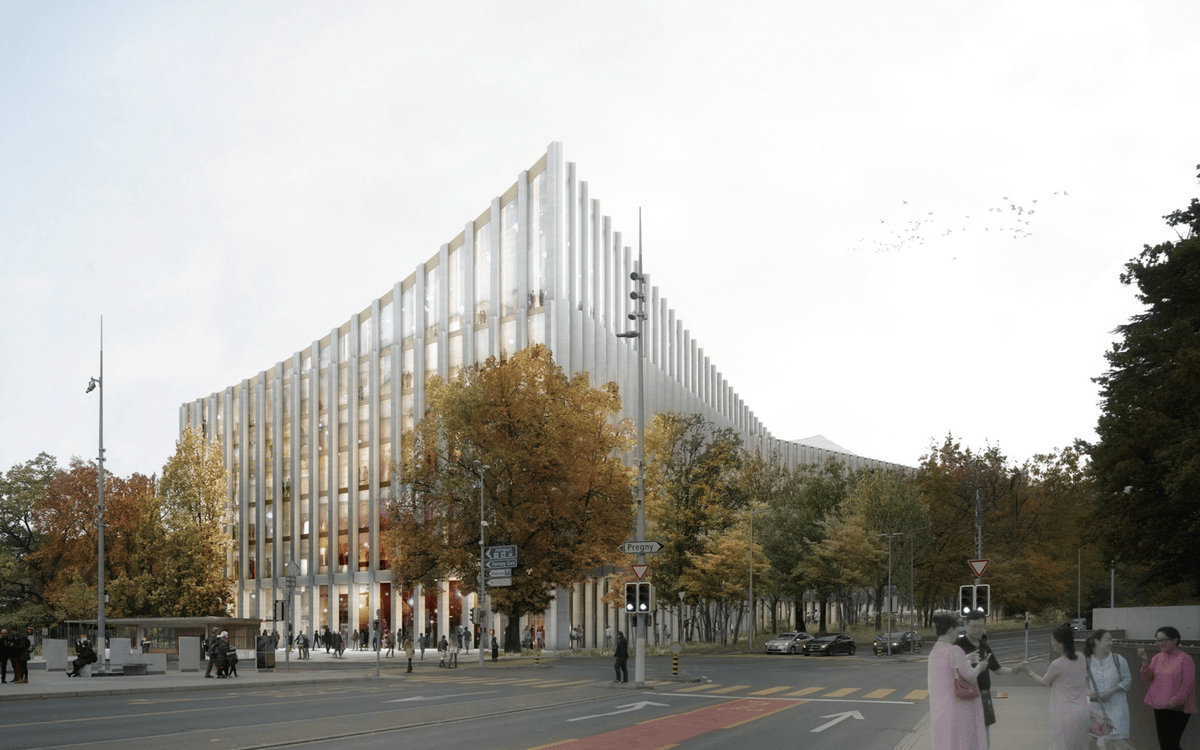 Bâtiment moderne avec façade en verre entouré d’arbres d’automne, situé au coin d’une rue animée.