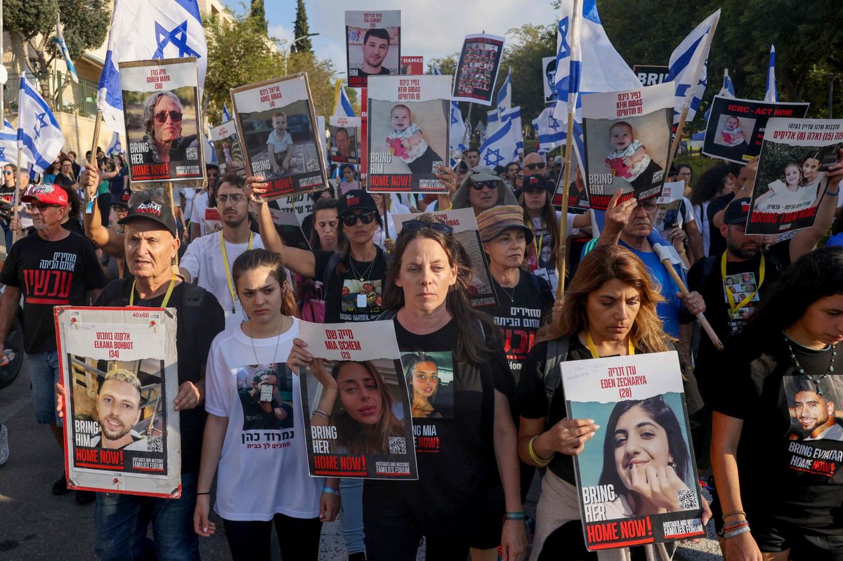 TOPSHOT - Relatives, friends and supporters of Israeli hostages held in Gaza since the October 7 attack by Hamas militants in southern Israel, hold placards and images of those taken during a protest for their release in the central city of Modiin on November 16 2023, as they march towards Jerusalem. (Photo by Menahem KAHANA / AFP)