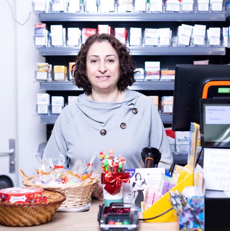 Femme dans un kiosque à Lausanne, entourée de produits, après la chute du régime Al-Assad, le 9 décembre 2024.