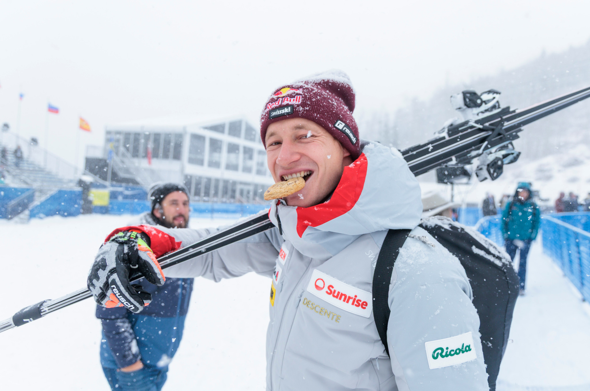 Marco Odermatt wears skis and bites into a cookie during downhill training at Beaver Creek 2025.