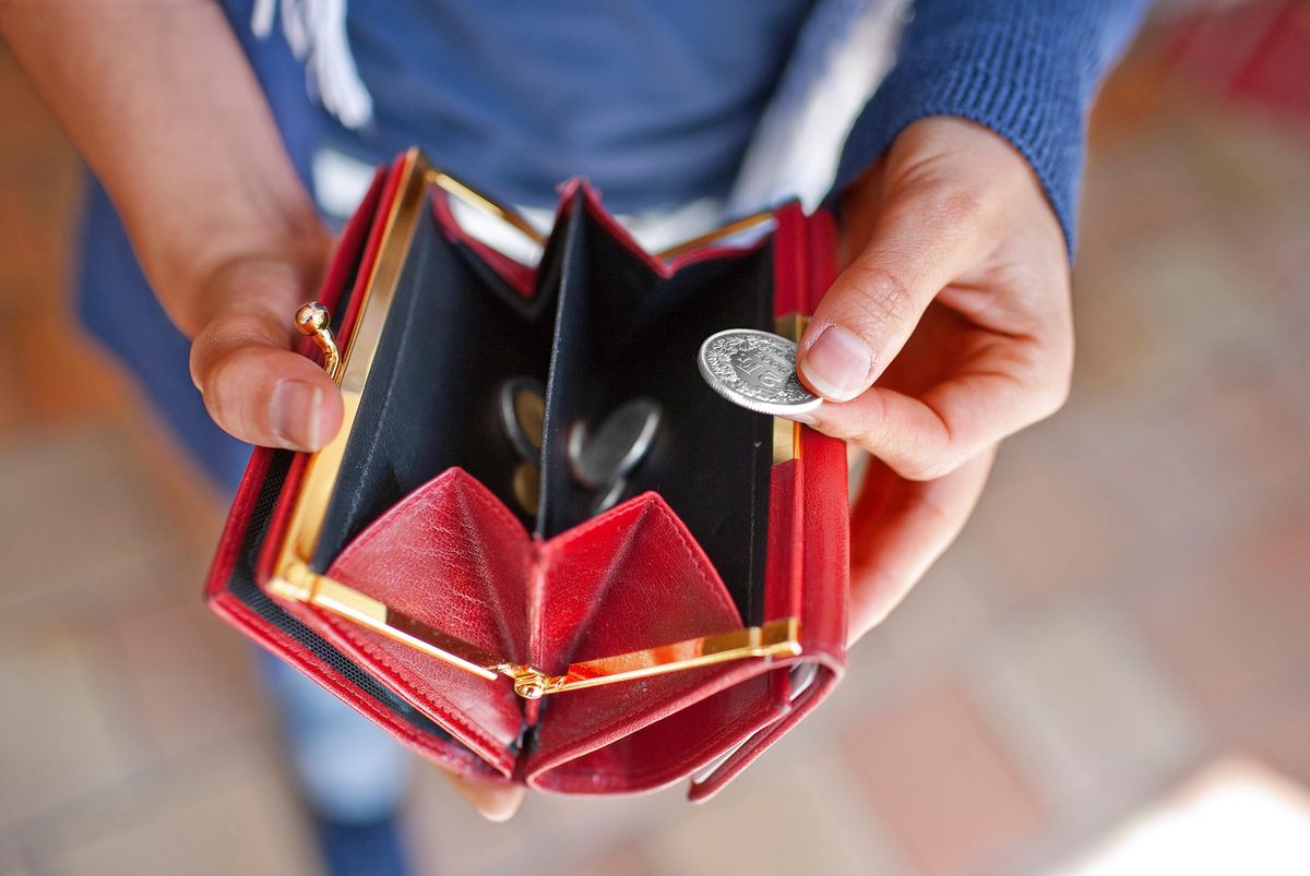 Une femme tenant un portefeuille ouvert avec des pièces, photographiée à Zurich le 10 juin 2009.