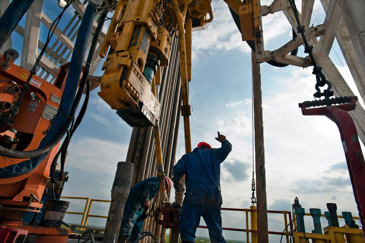A floor hand signals to the driller to pull the pipe from the mouse hole on Orion Drilling Co.'s Perseus drilling rig near Encinal in Webb County, Texas, U.S., on Monday, March 26, 2012. The Perseus is drilling for oil and gas in the Eagle Ford Shale, a sedimentary rock formation underlying an area of South and East Texas. Photographer: Eddie Seal/Bloomberg via Getty Images