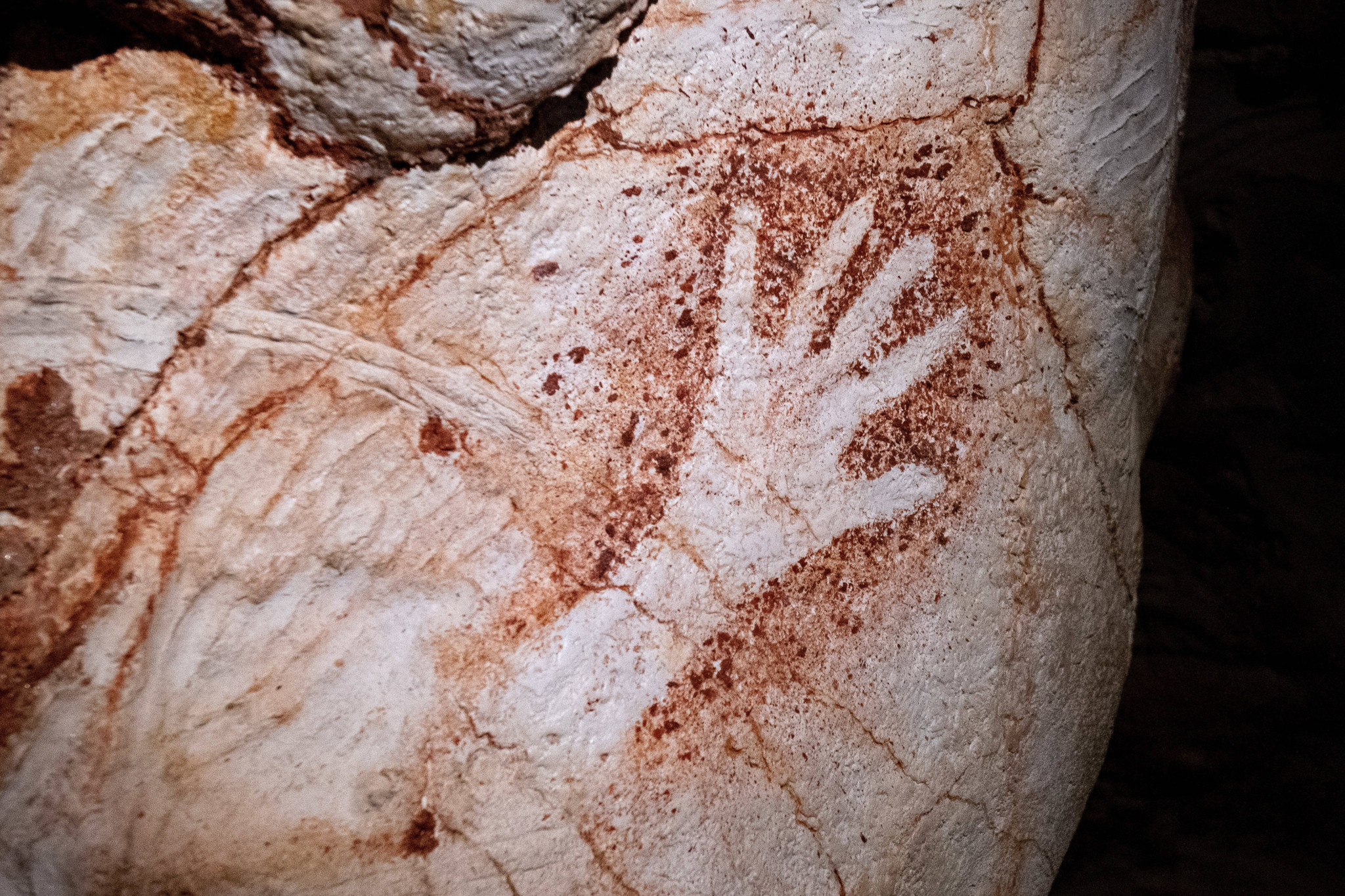 Negativer Handabdruck als Höhlenmalerei an einer Felswand in der Nachbildung der Cosquer-Höhle in Marseille.