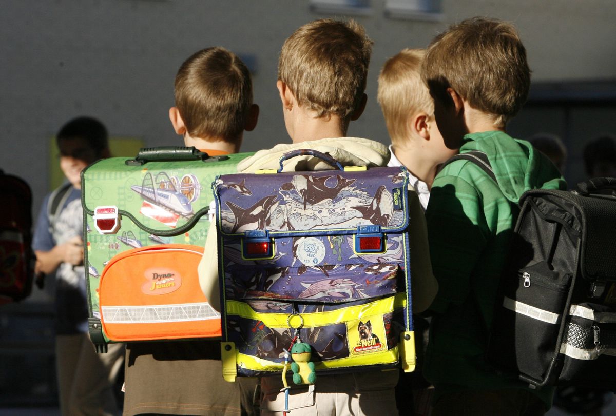 Kinder auf dem Schulweg am Montag, 18. August, 2008 in Stans. In den meisten Kantonen und Gemeinden der Schweiz beginnt heute nach den langen Sommerferien die Schule wieder, und es sind vermehrt unerfahrene Kinder im Strassenverkehr unterwegs. (KEYSTONE/Urs Flueeler)
