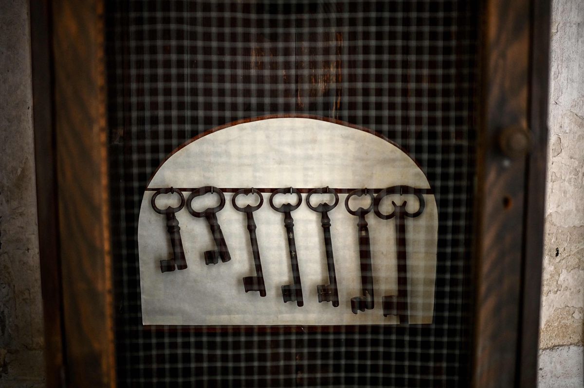 This photograph taken on April 26, 2024 shows keys hanging on a board at the entrance to a corridor leading to cells with an exterior locking system which used to accommodate dozens of girls aged 8 to 21 in a so-called preservation school (ecole de preservation) from 1905 to 1952, at the Cadillac castle in Cadillac-sur-Garonne, south-western France. The 16th century Chateau de Cadillac (Cadillac castle), built south of Bordeaux by the Duc of Epernon, was France's first women's prison, from 1818 to 1891, before being reconverted to a young women's preservation school, the equivalent of a juvenile corrections facility, until 1951. (Photo by Christophe ARCHAMBAULT / AFP)