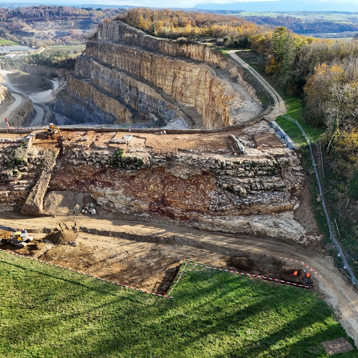 Vue aérienne des fouilles archéologiques sur la colline du Mormont à La Sarraz, montrant un mur celtique découvert près de la carrière Holcim.