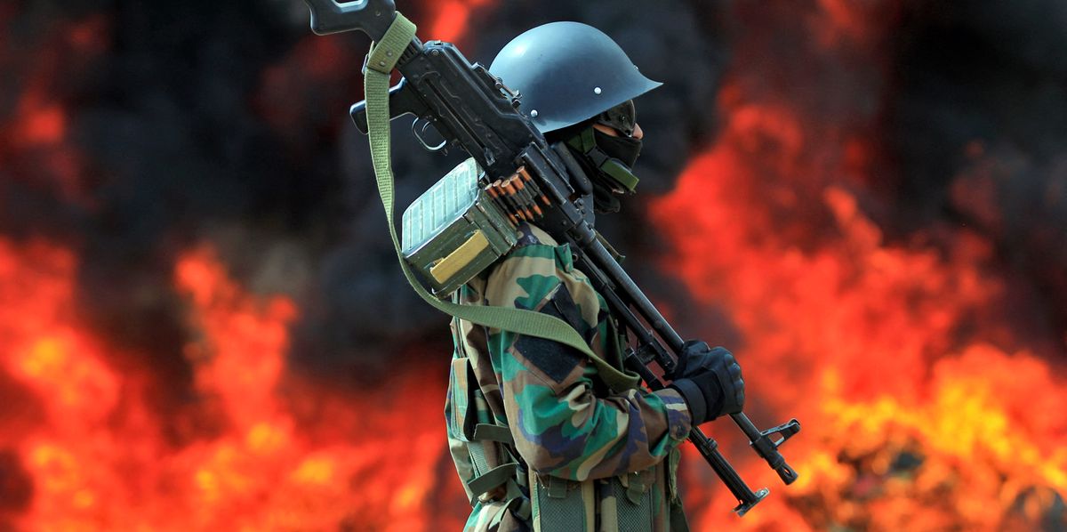 A member of security forces loyal to Yemen's Huthi rebels stands guard in front of a bonfire incinerating seized narcotic substances, in the Huthi-held capital Sanaa on June 26, 2022, the United Nations' designated "International Day Against Drug Abuse and Illicit Trafficking". (Photo by MOHAMMED HUWAIS / AFP)