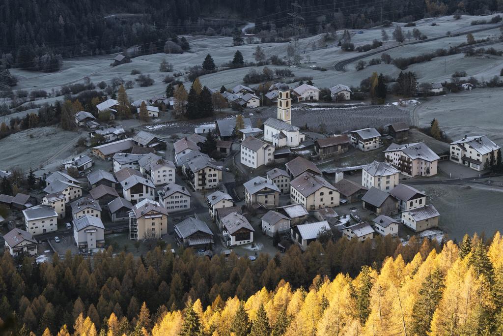 Vue aérienne du village de Brienz-Brinzauls en Suisse, le 15 novembre 2024, avec les maisons entourées de collines et de forêts en automne. Les habitants doivent évacuer en raison du risque d’éboulement.