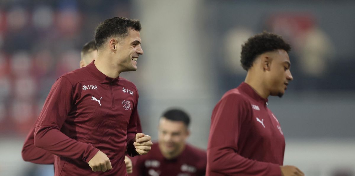 Granit Xhaka s'échauffe avant le match de la Ligue des Nations de l'UEFA contre la Serbie, portant un maillot rouge foncé.