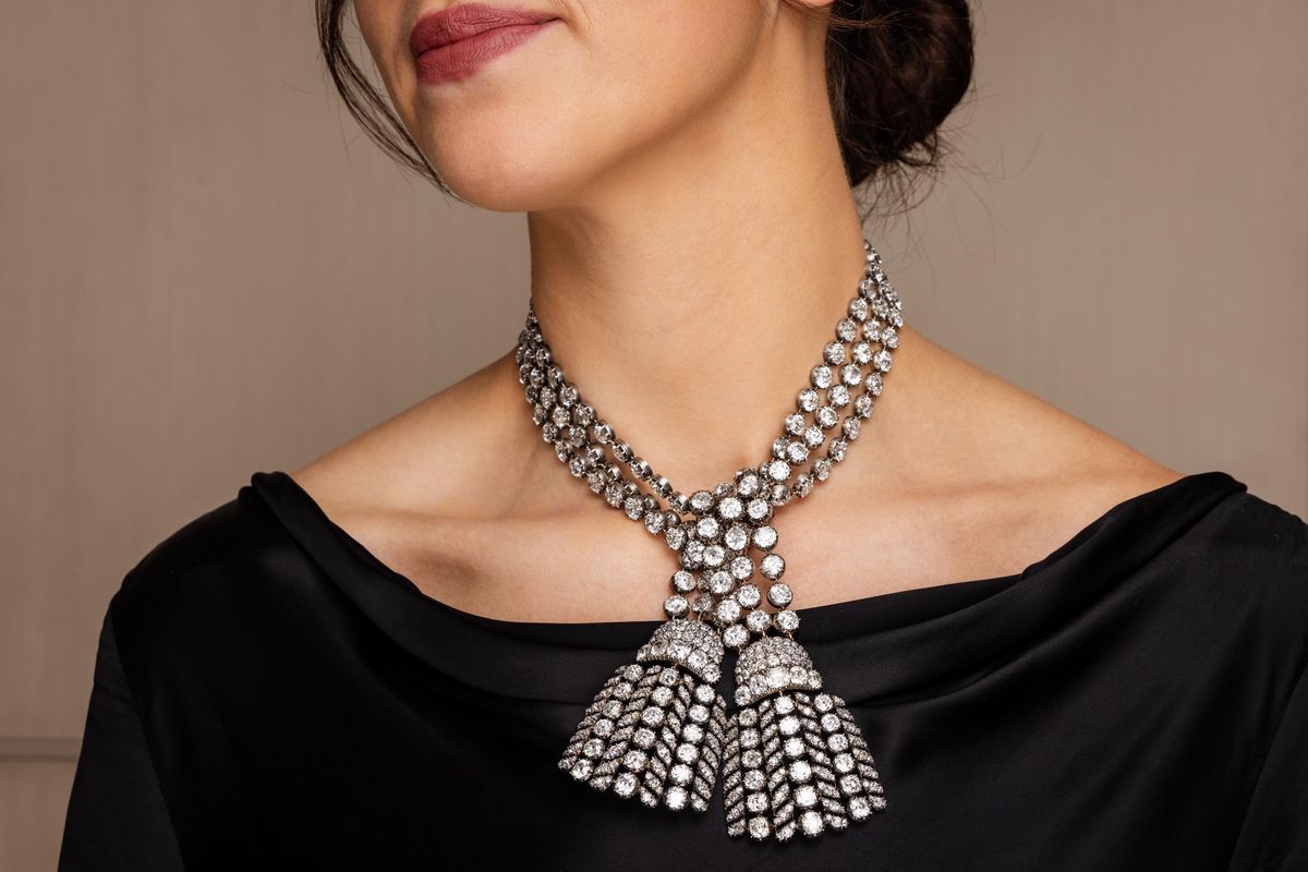 Collier en diamants étincelants porté par une femme en robe noire, mettant en valeur le design complexe et luxueux du bijou.