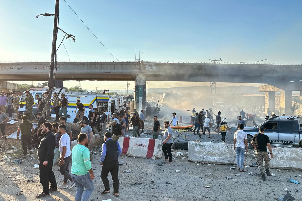 Pompiers et personnes rassemblées sur le site d'un camion piégé qui a explosé à un point de contrôle dans la ville syrienne d'Azaz