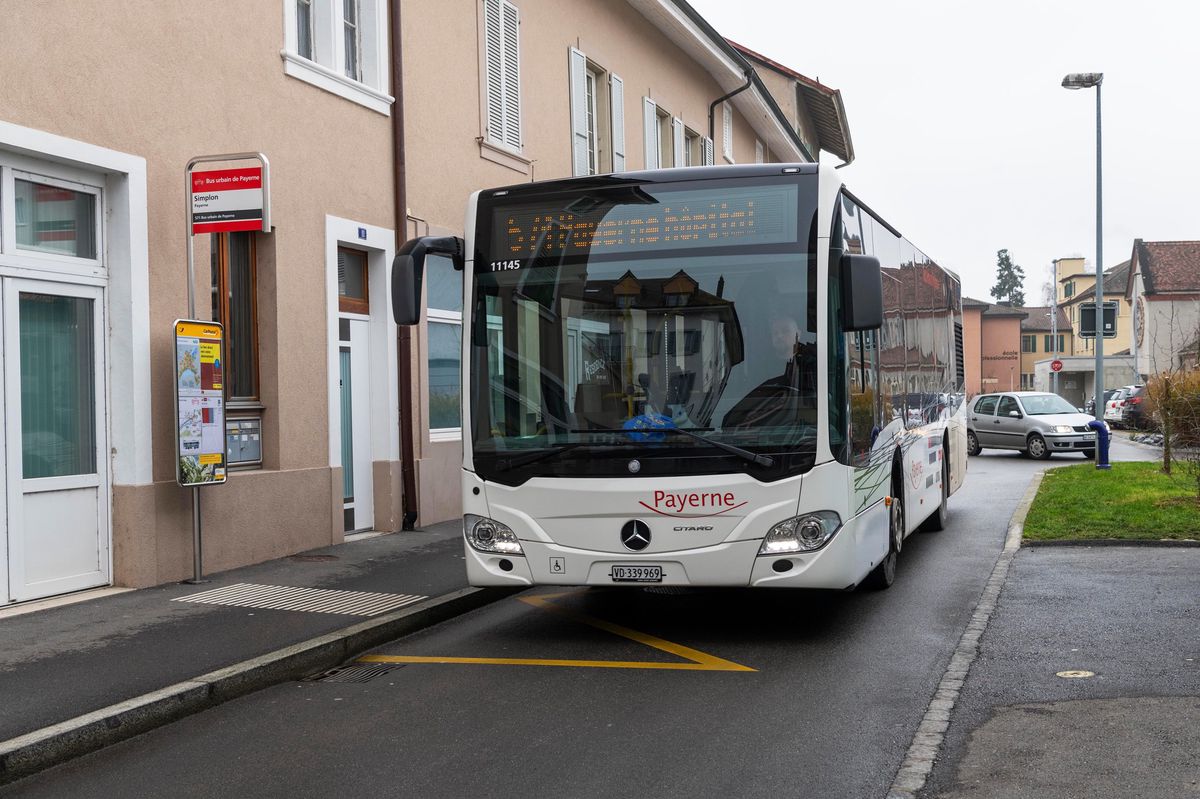 Bus urbain de Payerne stationné près d'un trottoir le 12 décembre 2020, avec des bâtiments résidentiels à proximité.