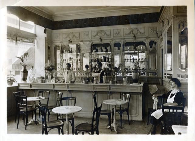 Intérieur Café Remor 1923 Derrière le bar Bortolo l’un des trois frères et sa femme Hilda, et la serveuse,  tante Paula.