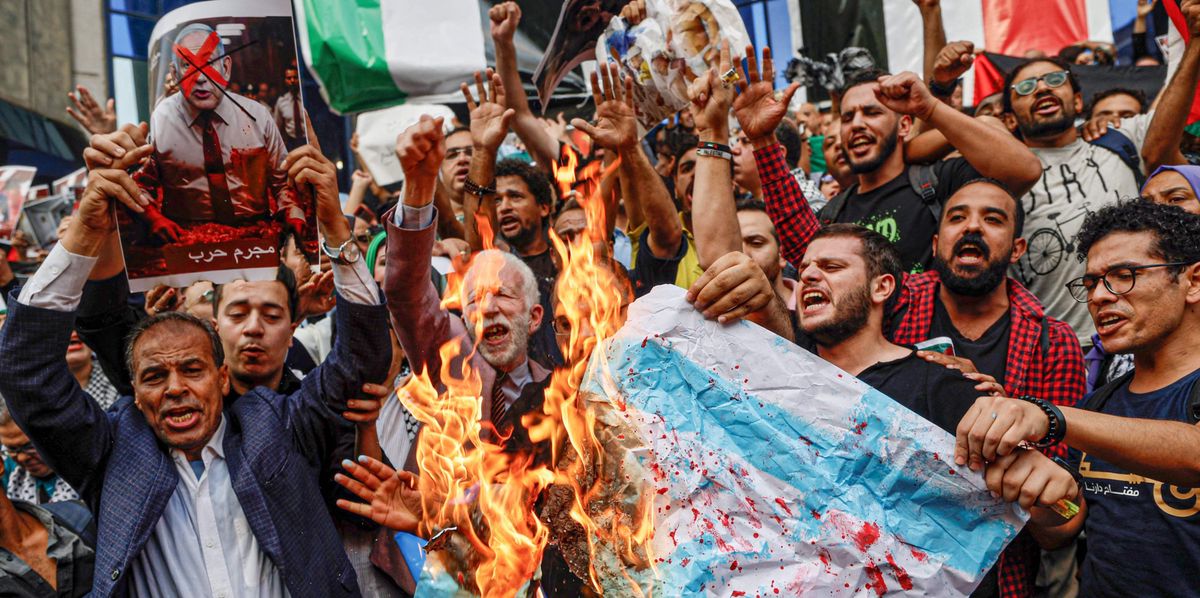 Egyptians burn Israeli flags as they take part in a demonstration outside the Syndicate of Journalists in downtown Cairo on October 18, 2023, protesting a strike on a Gaza hospital which killed hundreds a day earlier. Thousands rallied across the Arab and Muslim world on October 18 to protest the deaths of hundreds of people in a strike on a Gaza hospital that they blame on Israel, despite its denials. (Photo by Khaled DESOUKI / AFP)