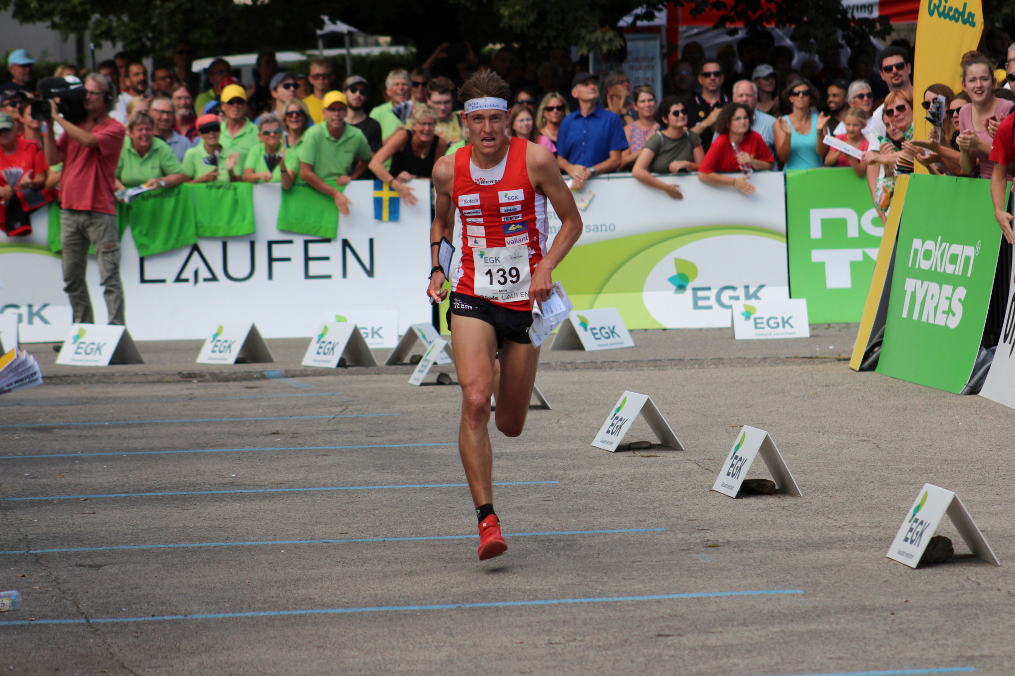 Matthias Kyburz beim Orientierungslauf-Weltcup 2019 in Laufen, in sportlicher Bekleidung und Startnummer 139, umgeben von Zuschauern.