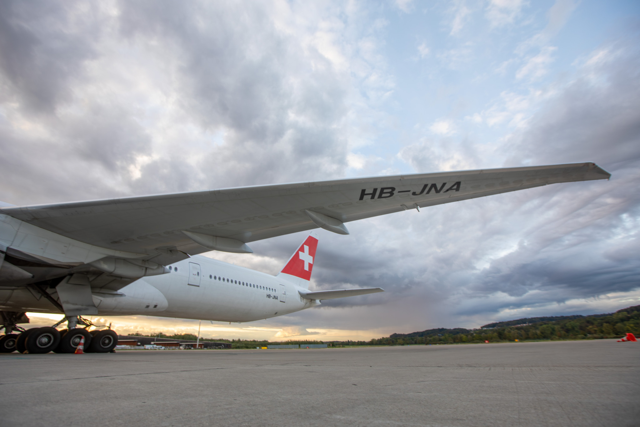 Flugzeugflügel eines Swiss International Air Lines Jets auf dem Rollfeld bei Sonnenuntergang.