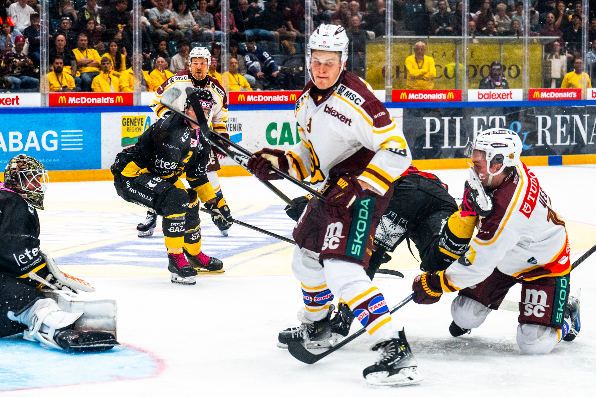 Match de hockey sur glace entre Genève-Servette HC et HC Ajoie à Genève. Jesse Puljujärvi et Jimmy Vesey de Genève-Servette affrontent Emile Veckaktins de HC Ajoie qui a reçu un coup de patin.