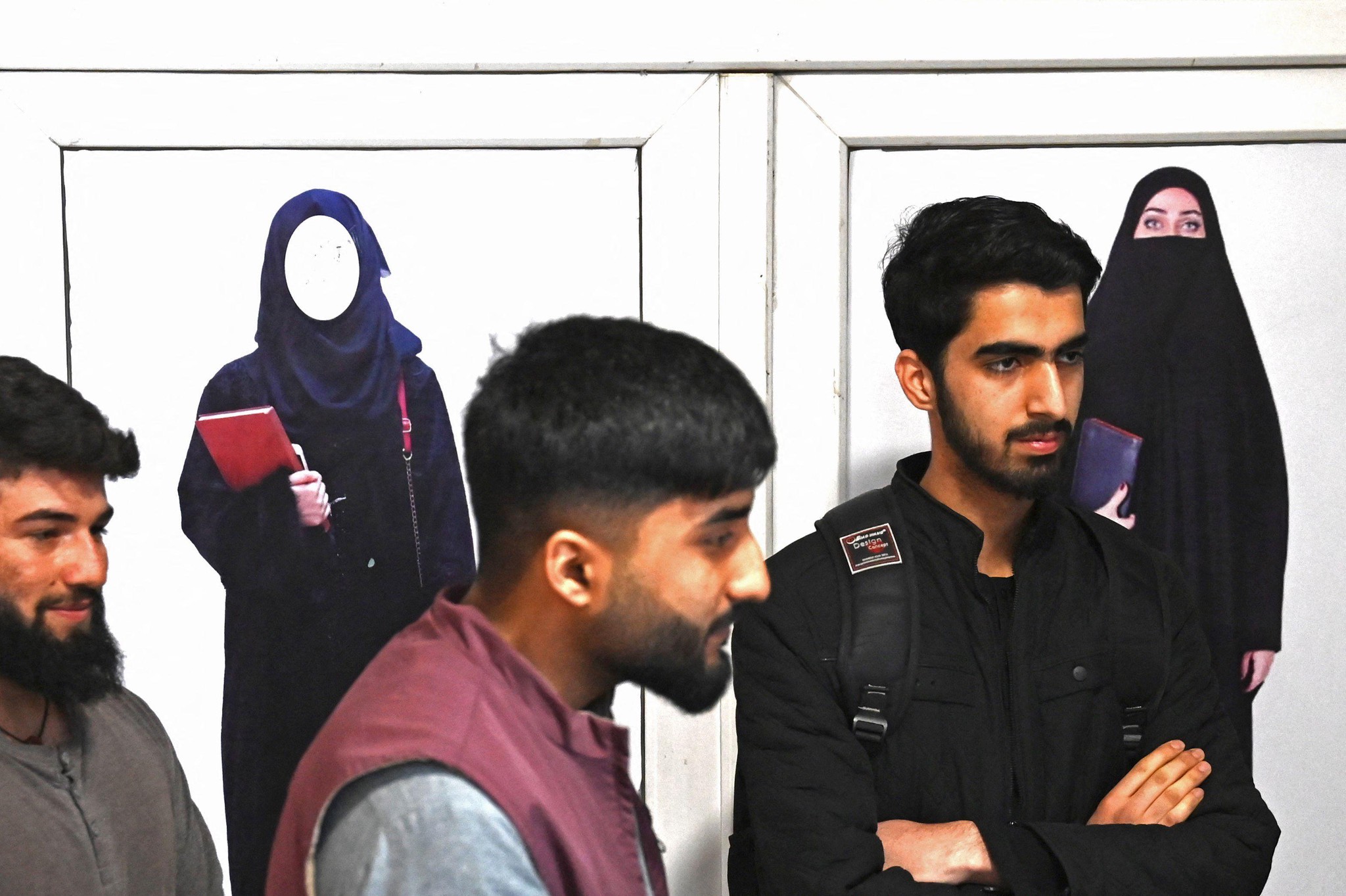Am 6. März öffneten die afghanischen Universitäten, aber nicht für Frauen. Studenten stehen vor Postern, die auf die Hidschab-Pflicht für Frauen aufmerksam machen. 