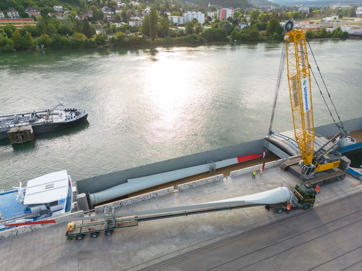 Jeudi 13 juillet au petit matin à Bâle. La péniche «Johanna M» vient d’arriver de Frise. À son bord, les morceaux de l’éolienne No 5 de Sainte-Croix, l’une des premières du canton de Vaud.