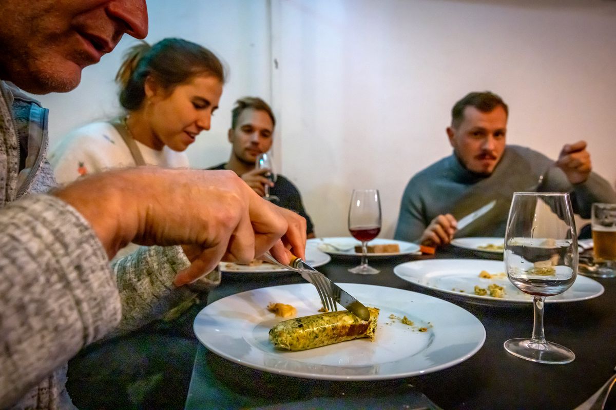 Quatre personnes dégustent des saucisses à une table lors de la Fête de la Saucisse à Genève, le 13 septembre 2024.