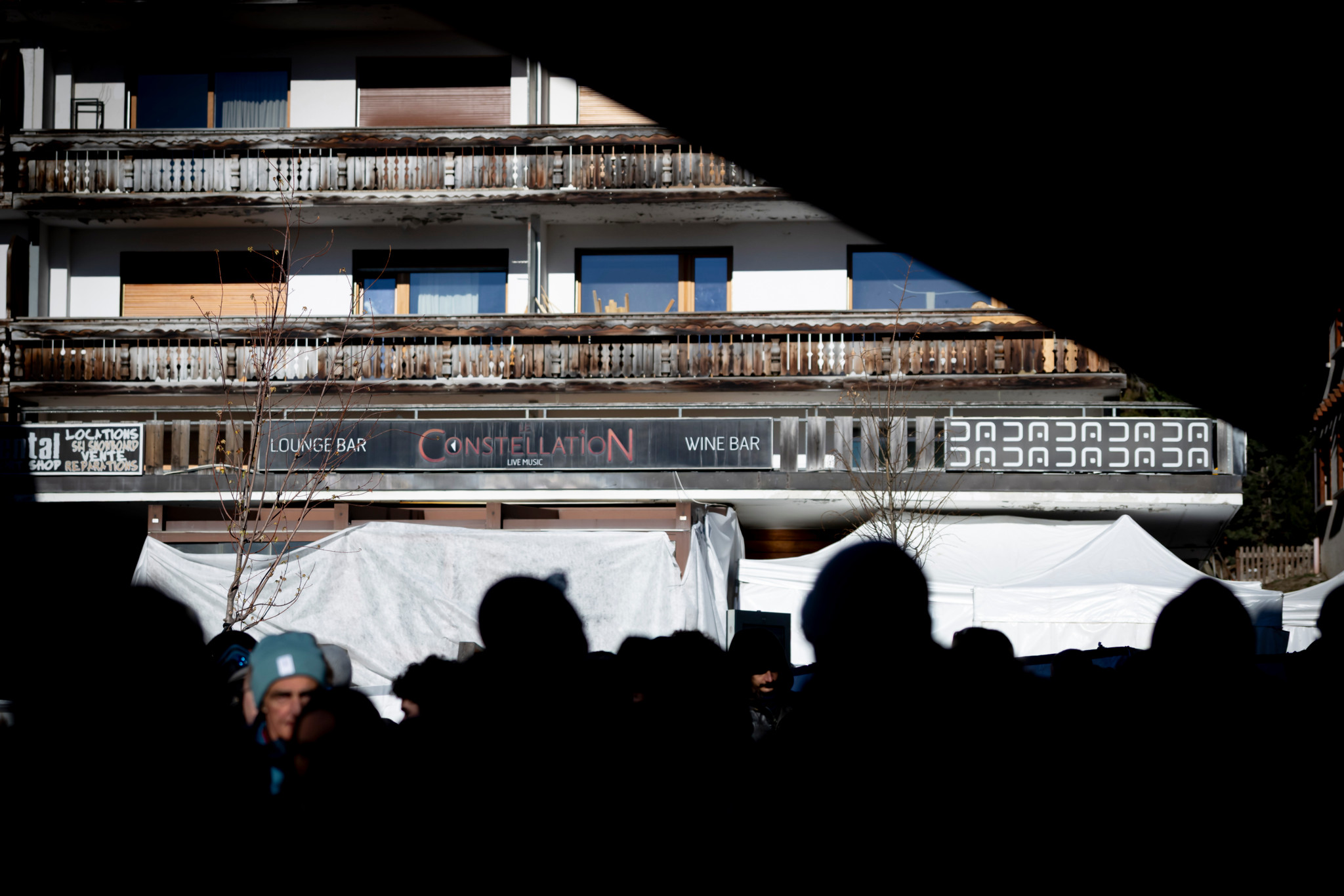 Trauernde gedenken der Brandopfer vor dem beschädigten Constellation Lounge Bar & Wine Bar in Crans-Montana, 4. Januar 2026.
