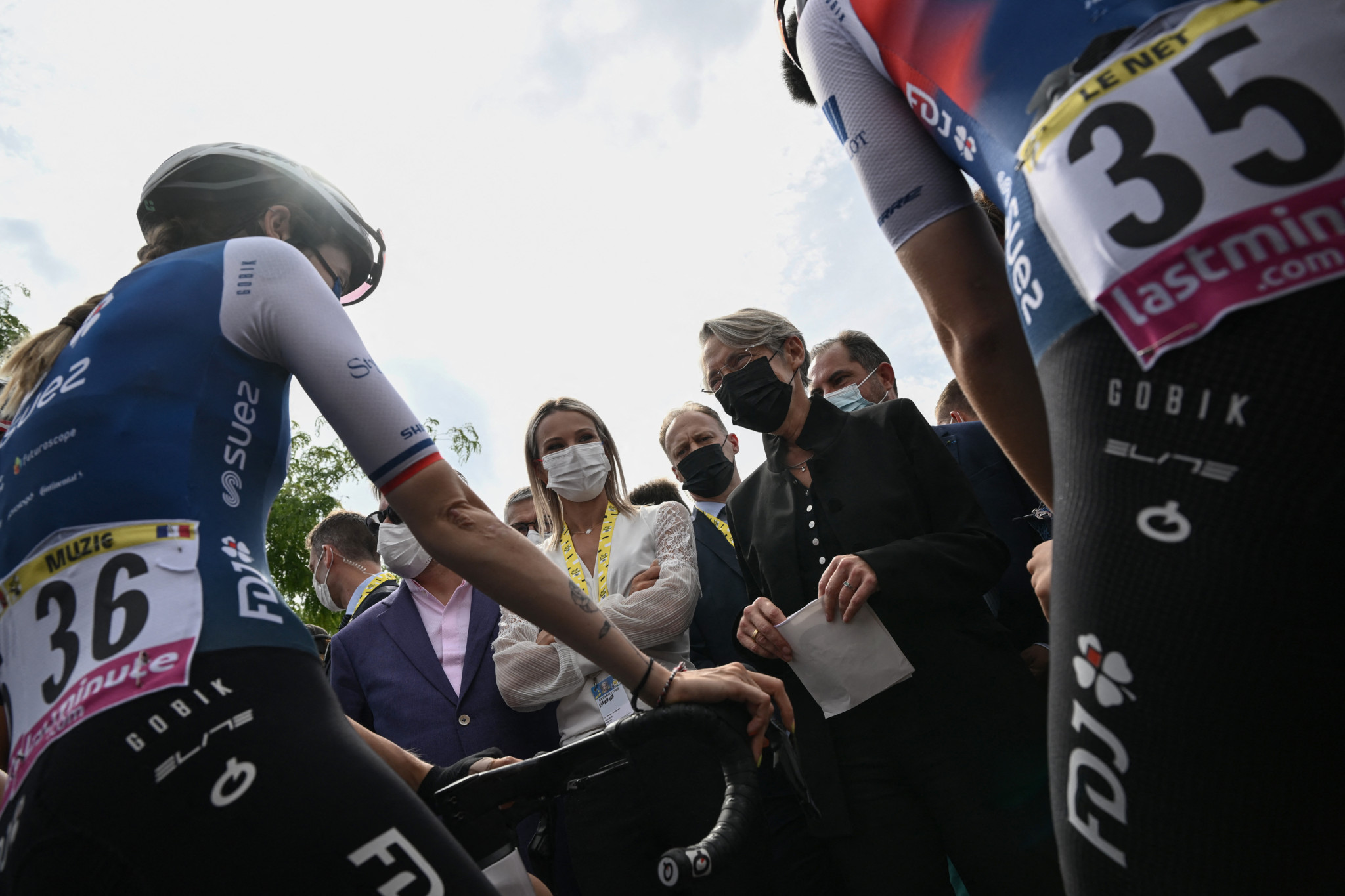 France's Prime Minister Elisabeth Borne (CR) greets FDJ SUEZ FUTUROSCOPE (FDS) French riders Marie Le Net (L) and Evita Muzic (R) next to French cyclist and Director of the Women's Tour de France Marion Rousse (CL) in the streets of Bar-le-Duc, eastern France, on July 28, 2022, as part of an official visit in the French departments of La Meuse and Les Vosges. (Photo by Jeff PACHOUD / AFP)