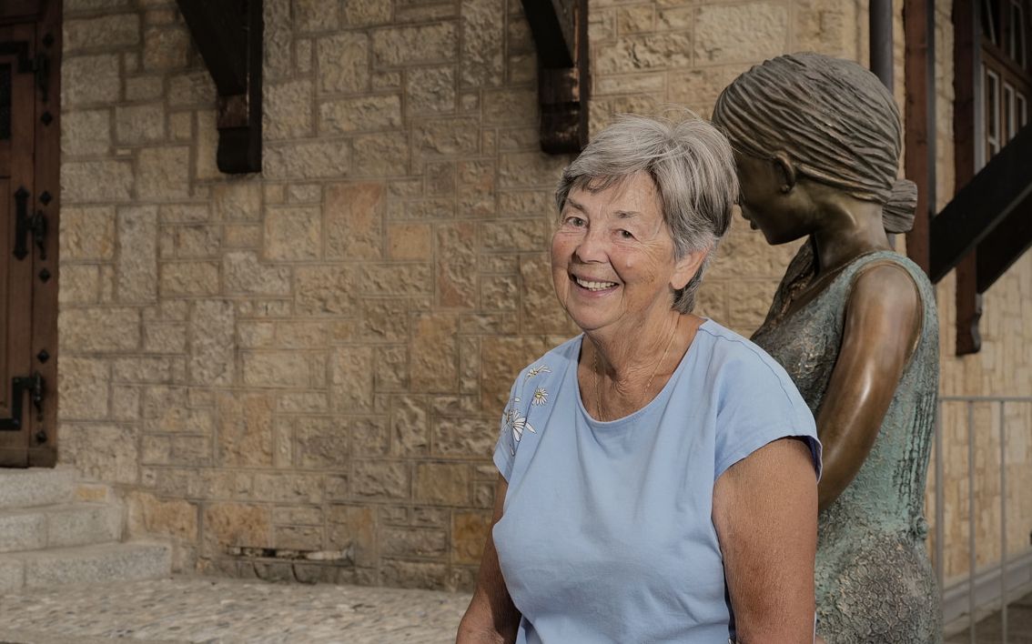 Noëlle Vuadens pose à côté de la statue de…, devant l’école de Russin.